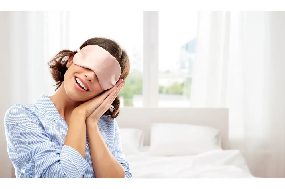 happy young woman in pajama and eye sleeping mask