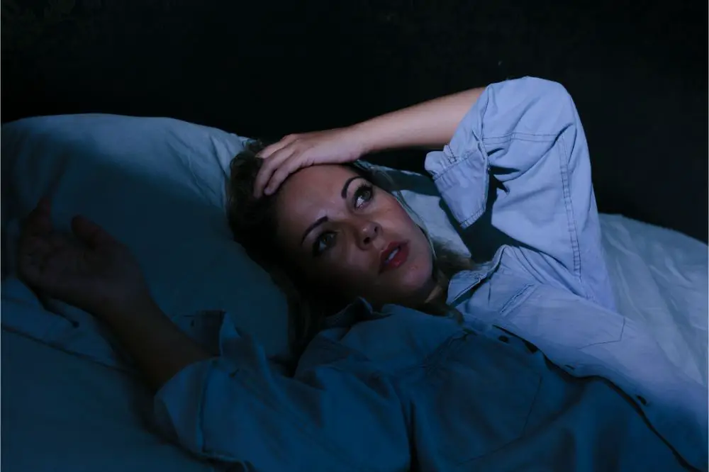 oung blonde woman lying on the bed awake