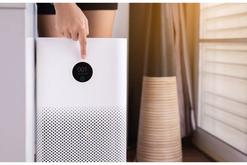 Woman hands pointing to screen of white modern air purifier 