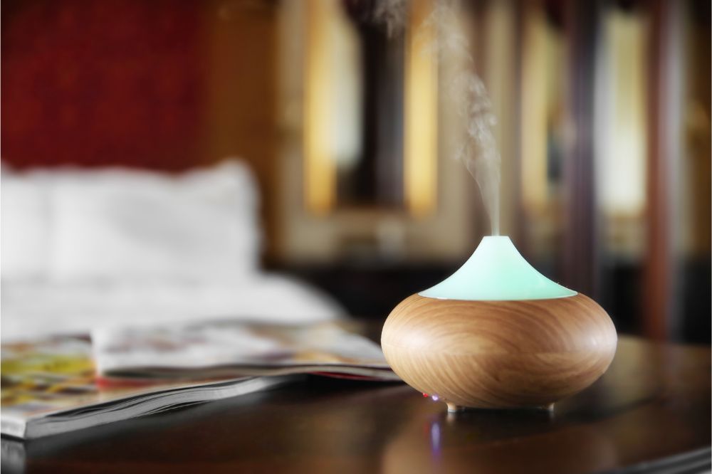 Aroma oil diffuser on wooden table in room