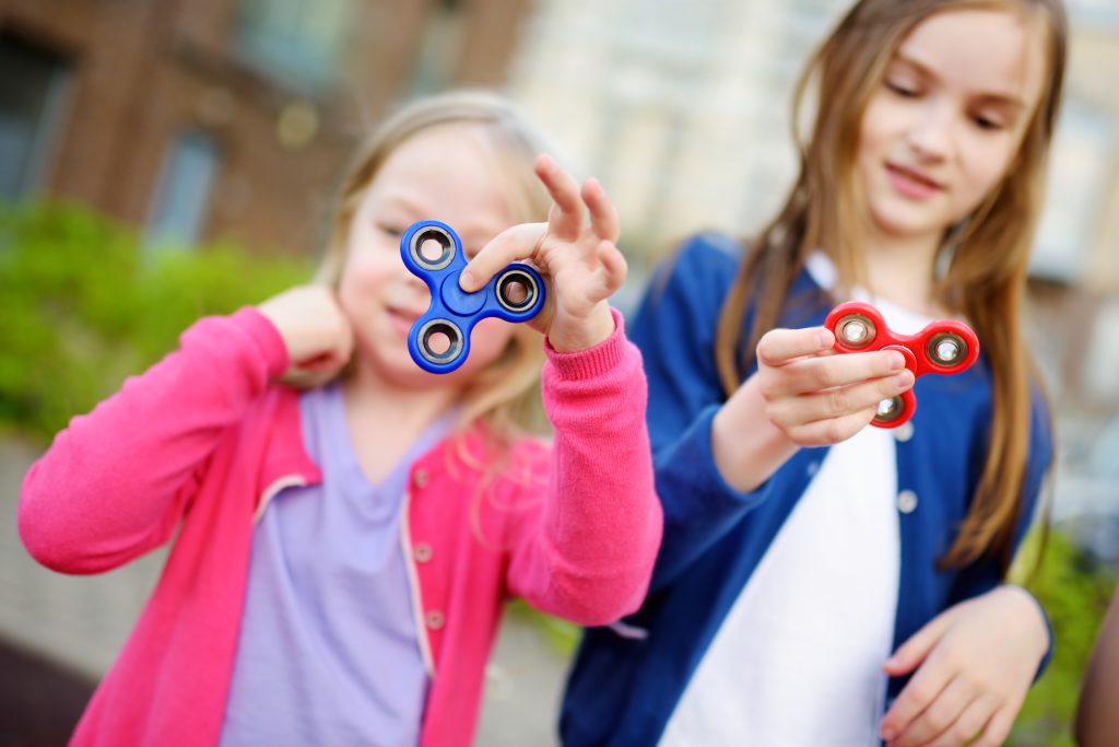 Two sisters playing with fidget spinners